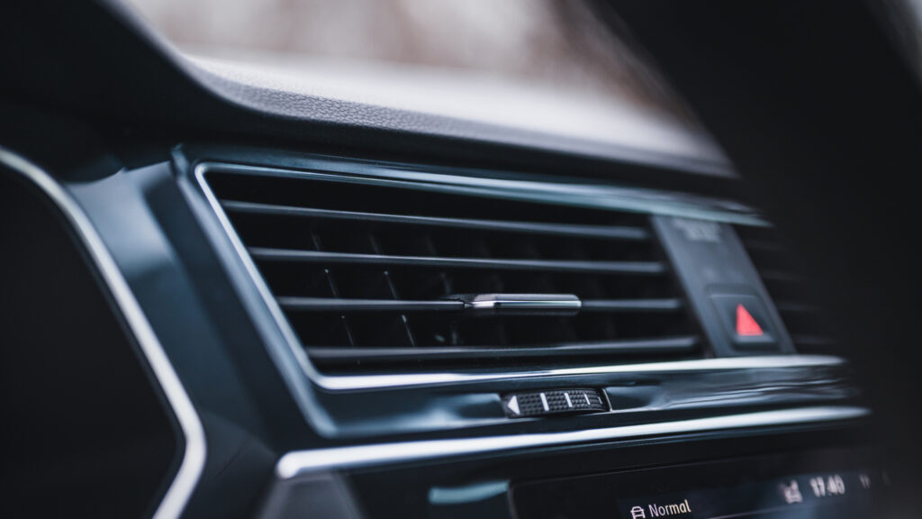 closeup of black ac vent on car dashboard