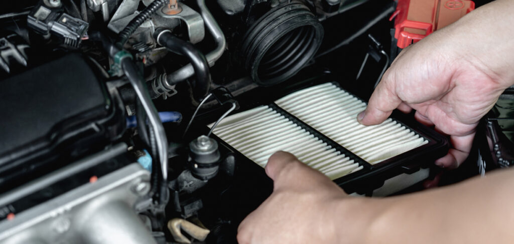 Mechanic performing maintenance on car air filter